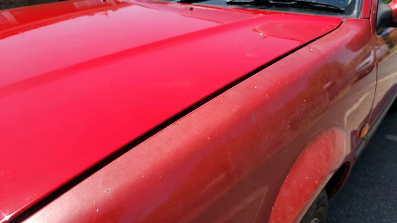 A repainted red bonnet next to a slightly faded original red wing